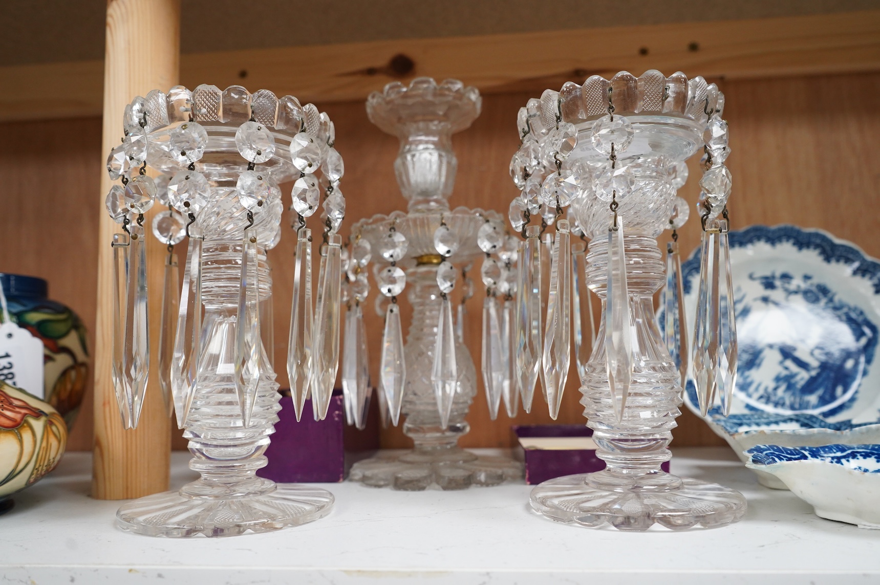 A pair of Victorian cut glass lustre candlesticks and one larger candlestick, 24cm high